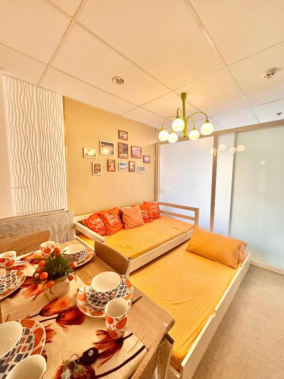 uma sala de estar com uma cama e uma mesa com pratos em 3 Smart Condominium in Cagayan de Oro City em Cagayan de Oro