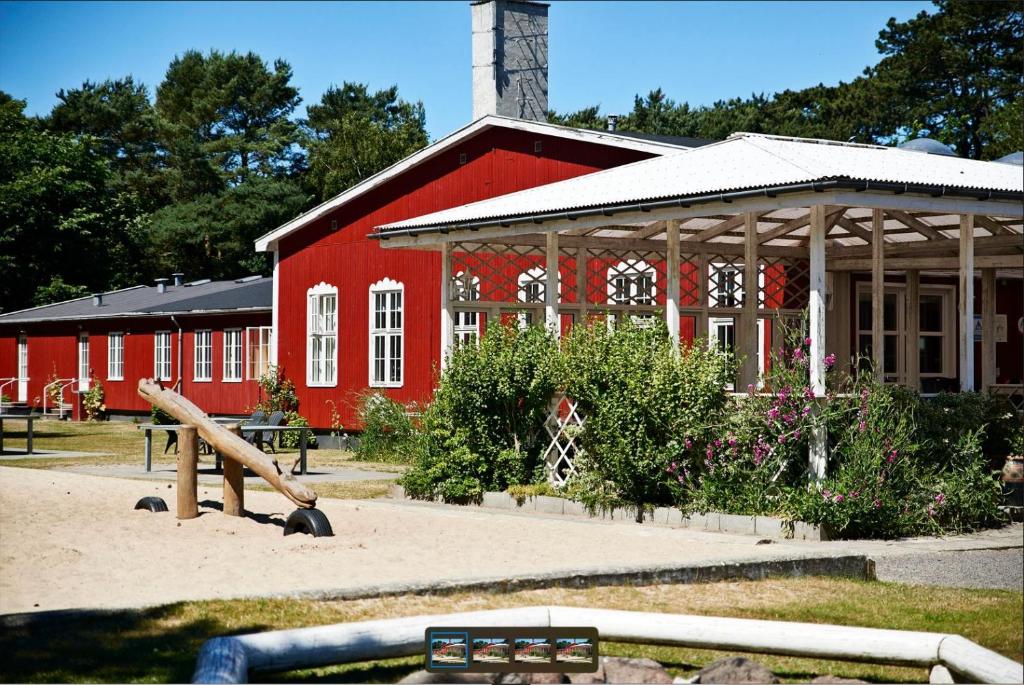 um edifício vermelho com um parque infantil em frente em Rønne Vandrerhjem em Rønne