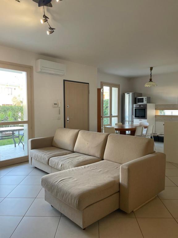 ein Wohnzimmer mit Sofa und eine Küche in der Unterkunft Villetta Rovizza in San Martino della Battaglia