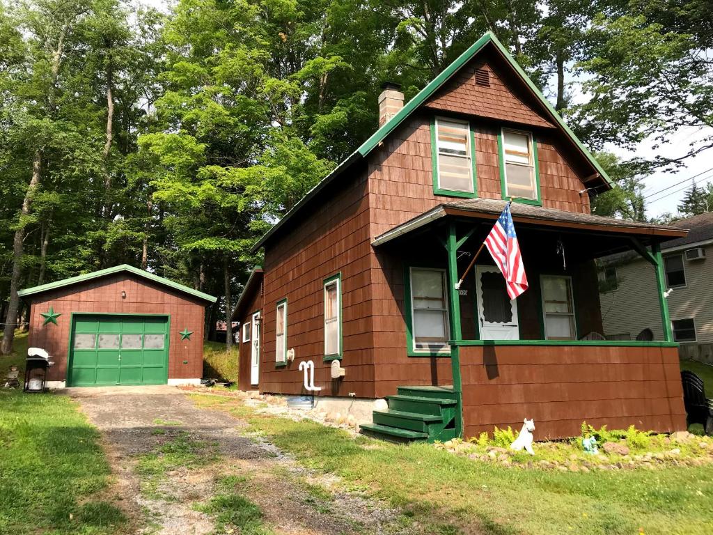 una casa con una bandera americana delante de ella en Camp North Country - Old Forge en Old Forge