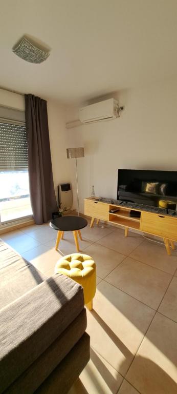 a living room with a couch and a tv at Espacio C Montevideo con estacionamiento in Córdoba