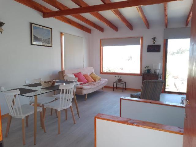 ein Wohnzimmer mit einem Tisch und einem Sofa in der Unterkunft Linda cabaña interior con piscina y entrada independiente en concon in Concón