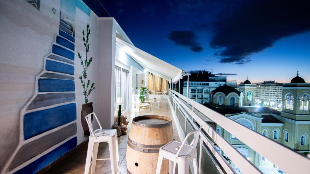 a balcony with two stools and a barrel at Piraeus Urban Gem in Piraeus