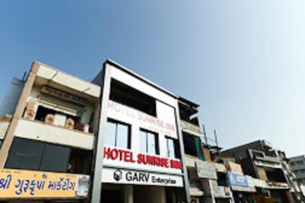 un bâtiment avec un panneau devant lui dans l'établissement Hotel Sunrise Inn, à Ahmedabad