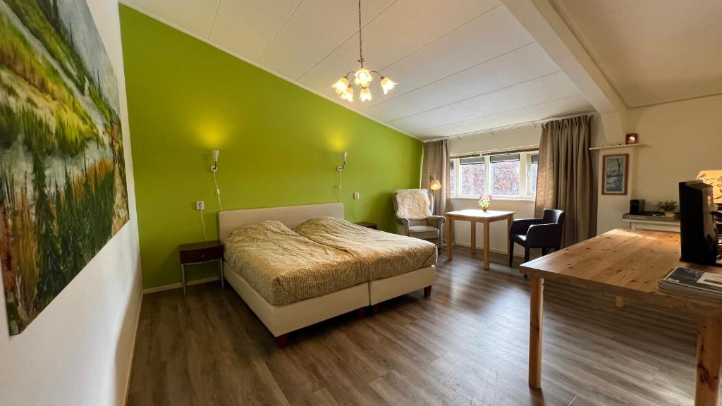 een slaapkamer met een bed en een groene muur bij De Sternhof in Zeewolde