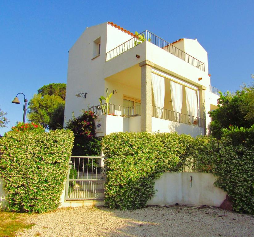 una casa blanca con arbustos delante en B&B Limone, en San Teodoro