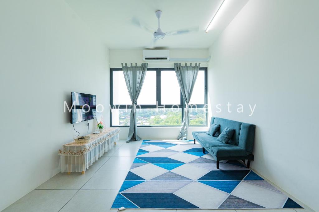 a living room with a blue couch and a large window at Cozy&Comfy Suite Room Perai in Perai