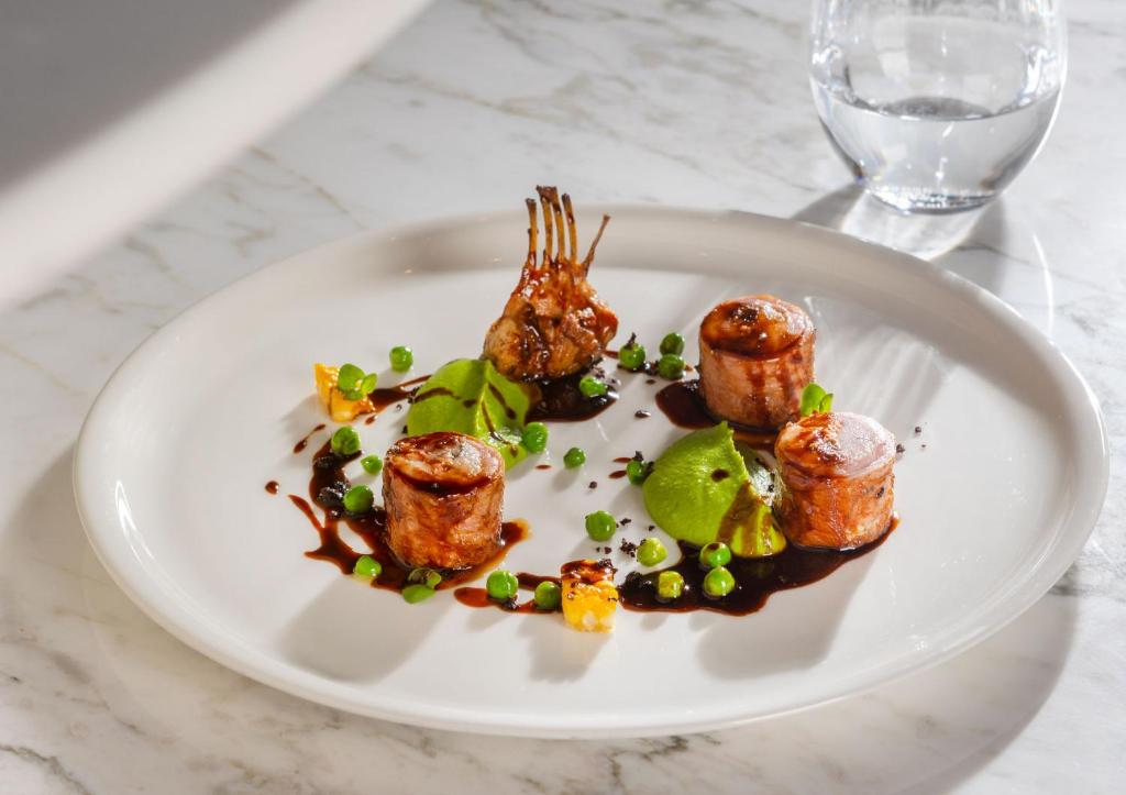 a white plate with food on a table at City of Dreams Mediterranean - Integrated Resort, Casino & Entertainment in Limassol