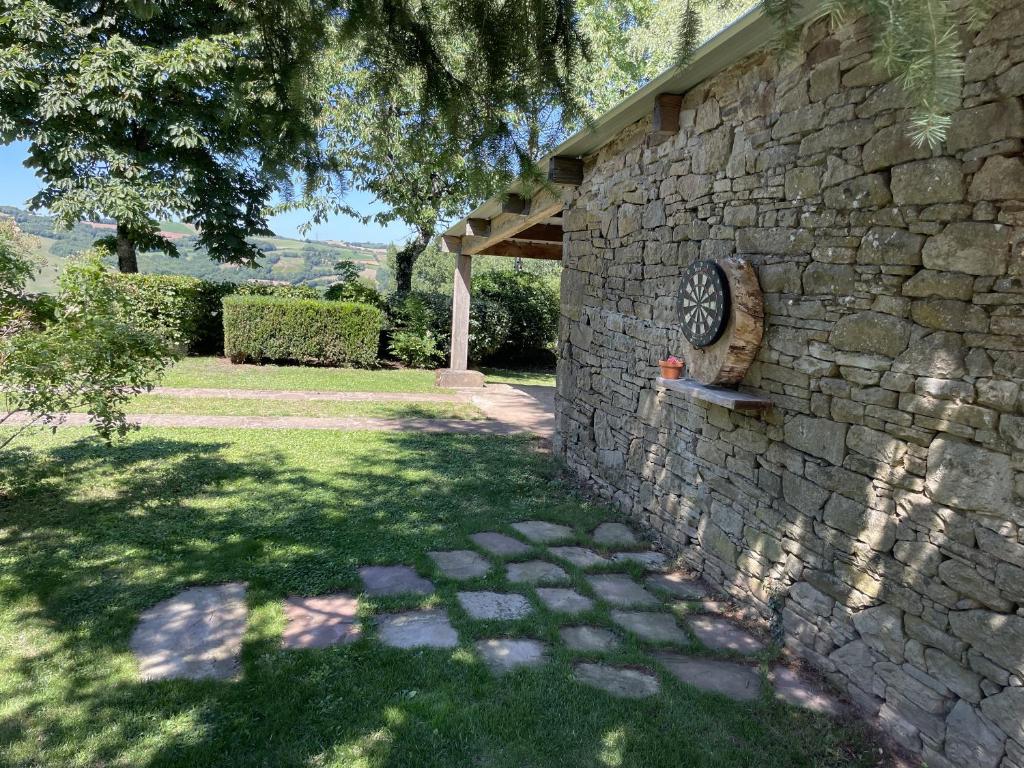 a stone wall with a clock on the side of it at La maison Léopoldine 