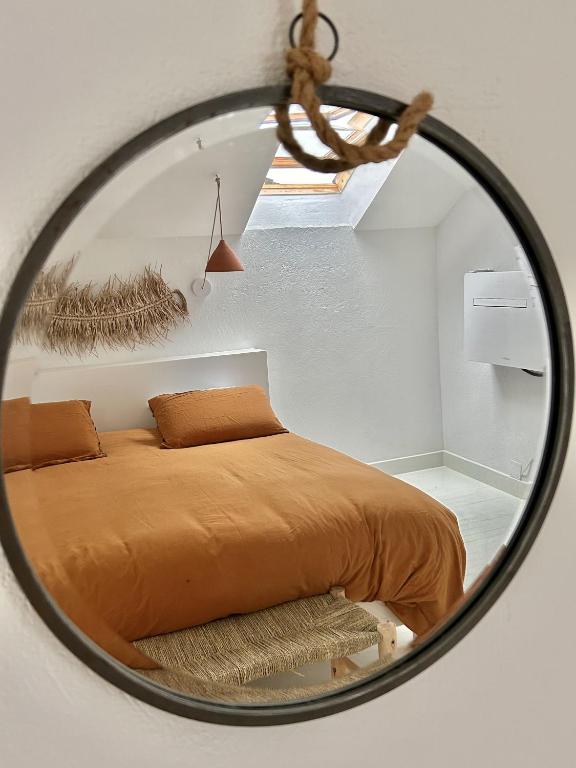 a mirror reflecting a bed in a bedroom at La maison Léopoldine 