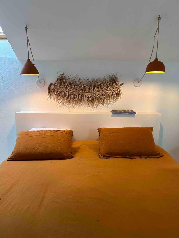 a bedroom with a bed with two pillows on it at La maison Léopoldine 