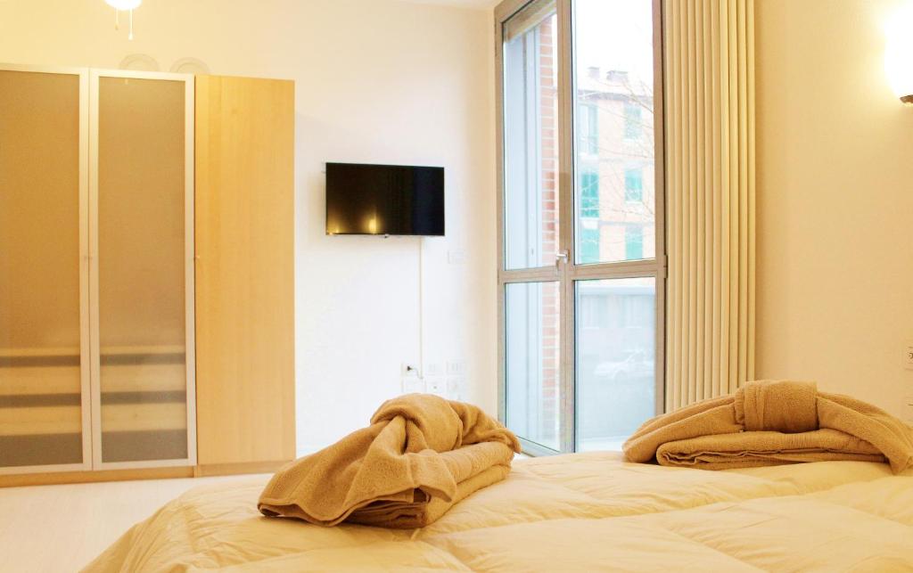 a bed in a room with a large window at Appartamento Levante in Bologna