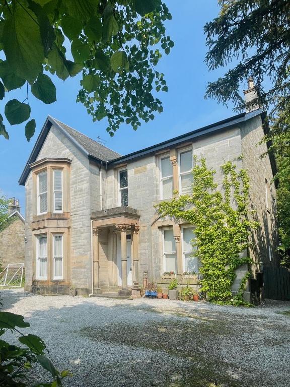 an old stone house with a driveway at Bishopton Apartment, near Glasgow in Bishopton