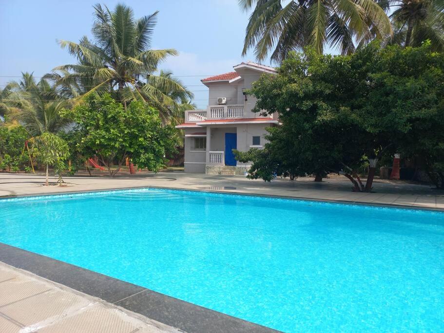 uma grande piscina azul em frente a uma casa em Murud Hospitality (Madni Villa) em Vihur