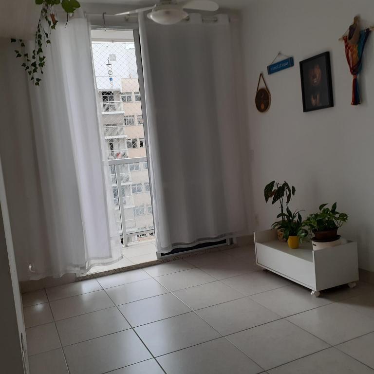 a living room with a window and a white tile floor at Canto do sabiá in Rio de Janeiro