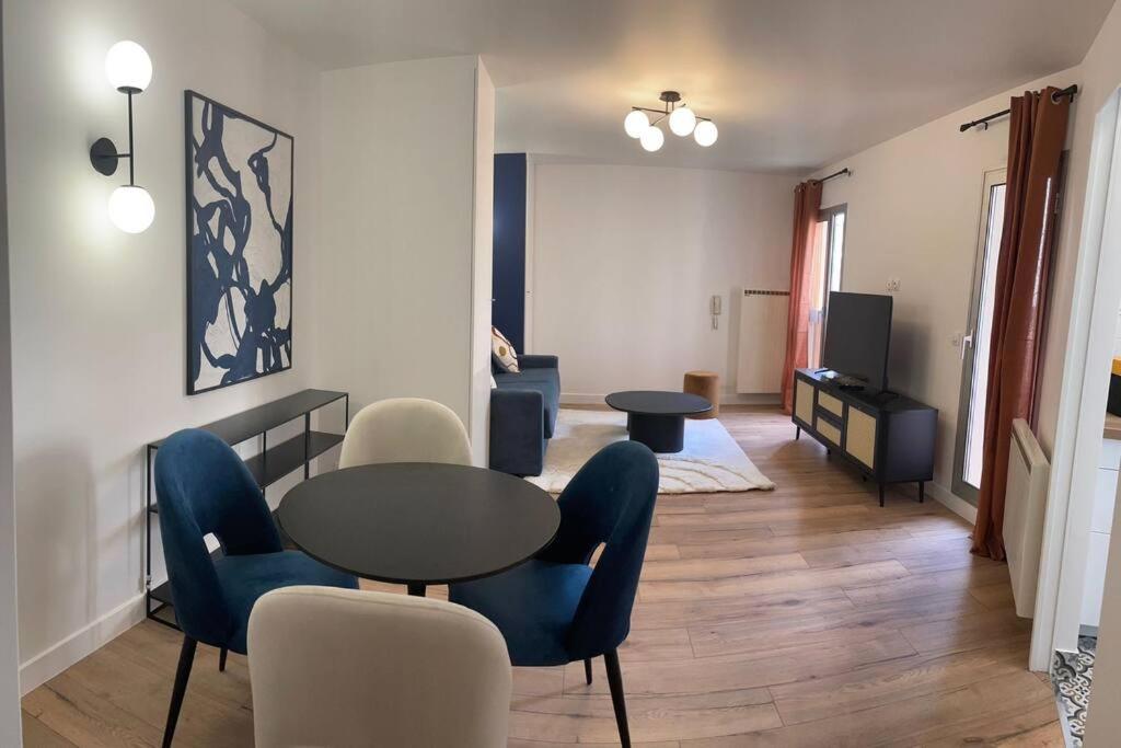 un salon avec une table et des chaises dans l'établissement Le Botanique - À deux pas de Paris - 319B, à Rueil-Malmaison