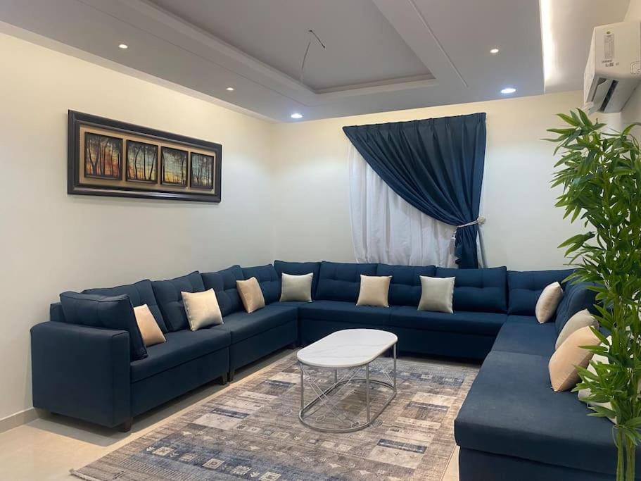 a living room with a blue couch and a table at شقق ايلاف طيبة in Al Madinah