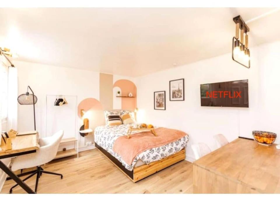 - une chambre avec un lit et un bureau dans l'établissement Charmant studio lumineux calme, à Asnières-sur-Seine