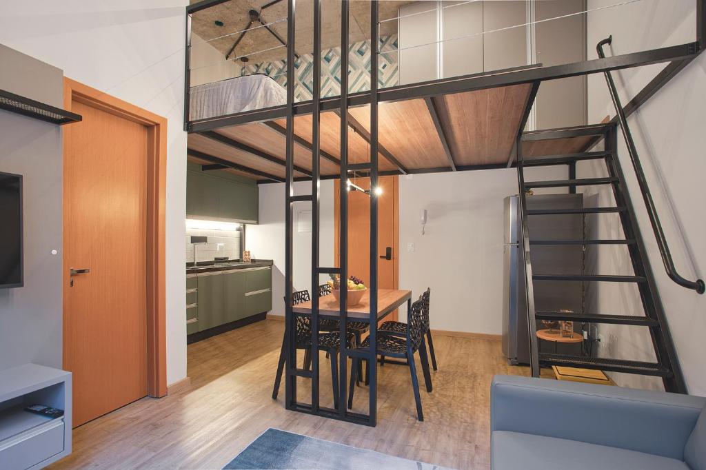uma sala de estar com uma cama alta e uma sala de jantar em Loft 102 em Curitiba
