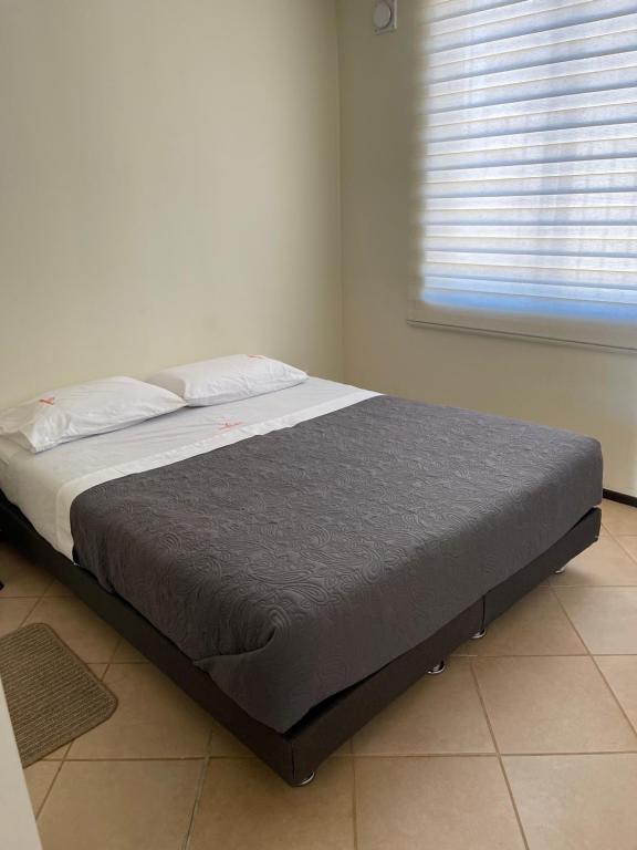 ein Bett in einem Schlafzimmer mit einem Fenster in der Unterkunft Casa 2 personas cama matrimonial in Talca
