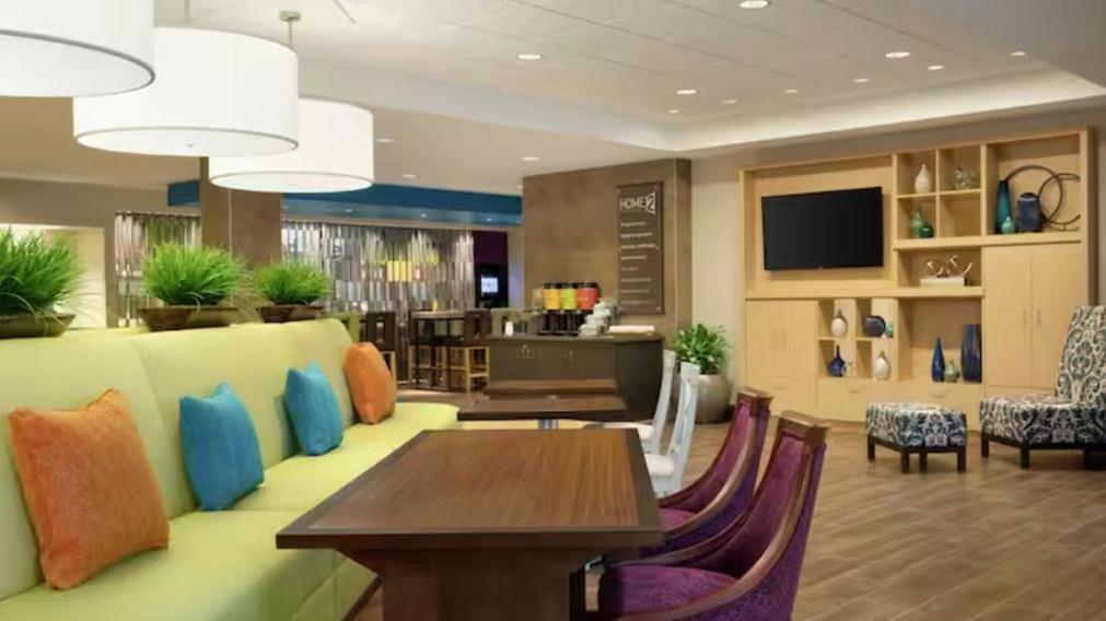 Home2 Suites By Hilton Lubbock University في لوبوك: غرفة معيشة مع أريكة وطاولة وكراسي