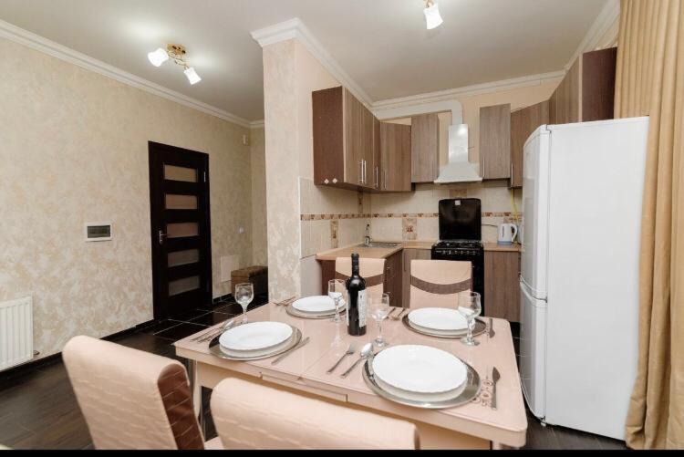 cocina con mesa y nevera blanca en Stylish apartment 001, en Chişinău