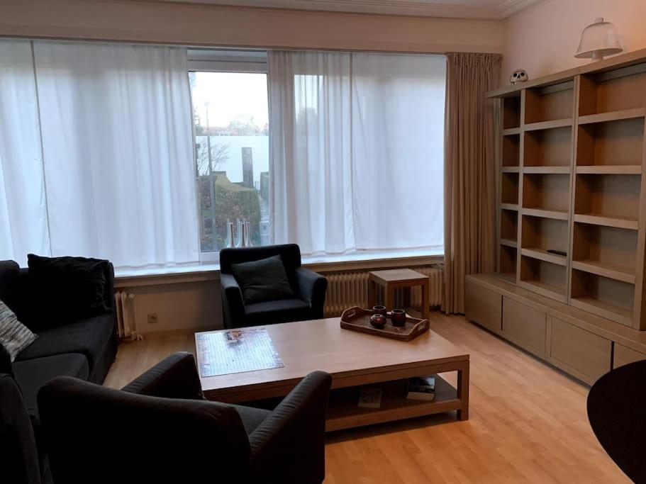 een woonkamer met een tafel en 2 stoelen bij Une belle étage à Stockel in Brussel