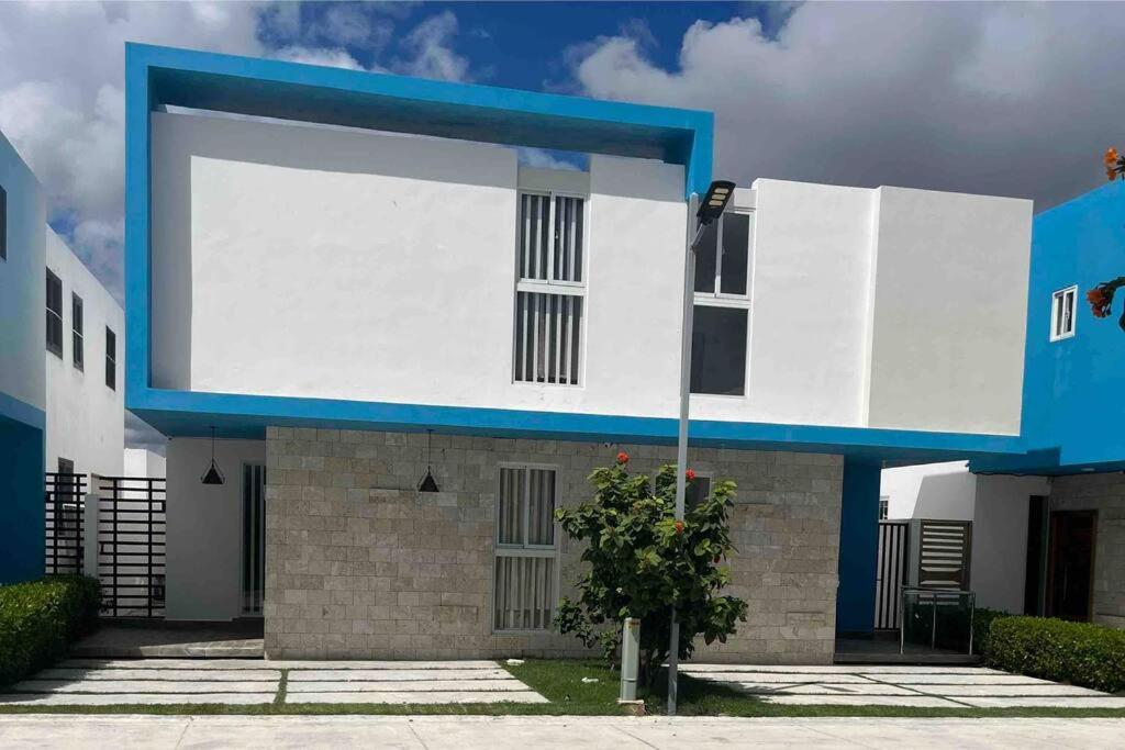 una casa azul y blanca con un árbol delante en Espectacular alojamiento, en Punta Cana