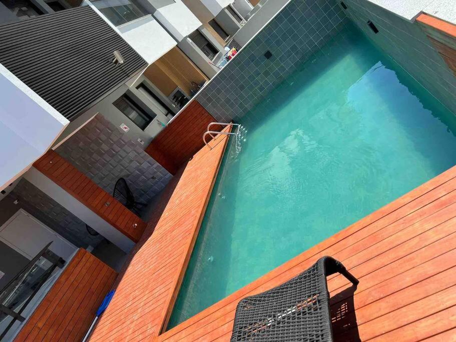 a swimming pool with a chair next to a building at Praia de Palmas, Residencial Anito Petry! in Governador Celso Ramos