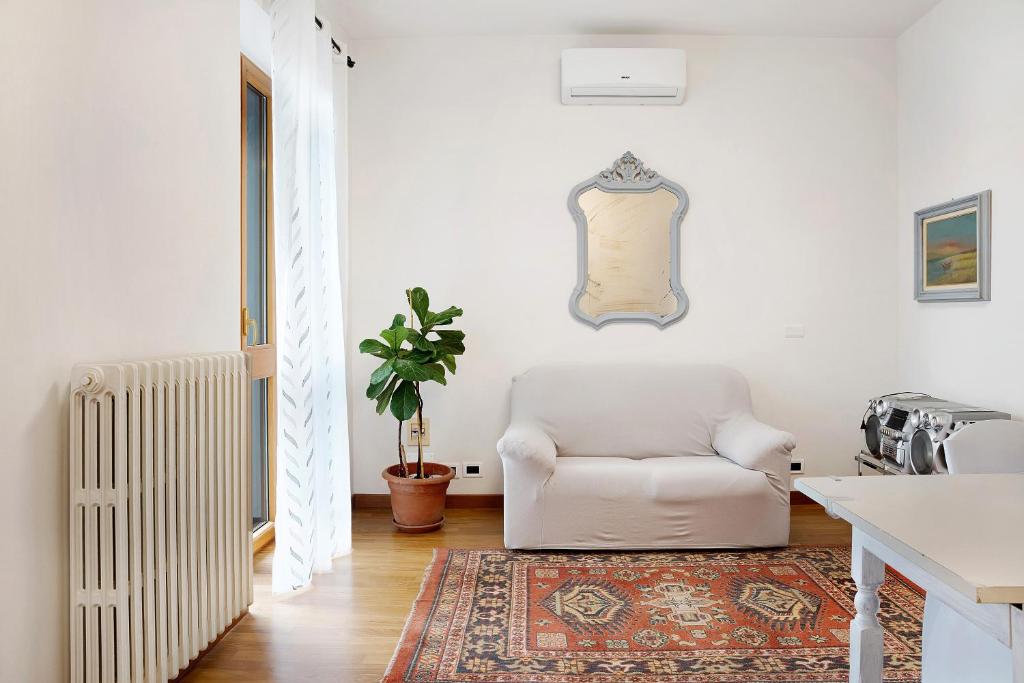 a living room with a white chair and a rug at Casa Gallinotto in Alba