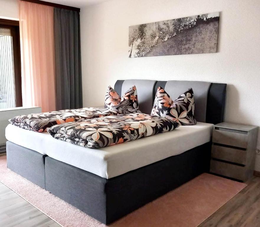 a bed in a bedroom with a bed frame with pillows at Urlaub und Wellness im Fichtelgebirge in Warmensteinach