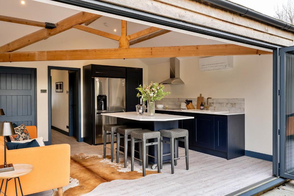 uma cozinha em plano aberto e sala de estar com mesa e cadeiras em Finest Retreats - The Stables at Lilac Cottage em Hawling