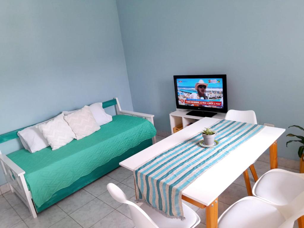 a room with a bed and a table and a tv at LOS RULITOS Departamentos Temporarios in San Salvador de Jujuy