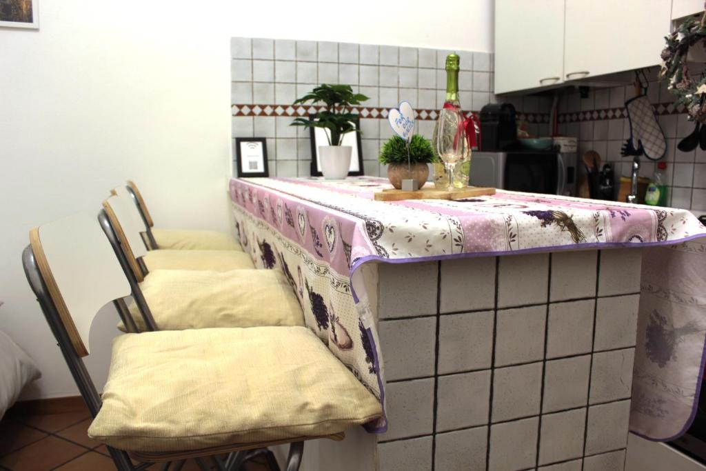 eine Küche mit einer Theke mit Stühlen und einem Tisch in der Unterkunft La Corte dei Creativi Comodo e Centrale in Mailand