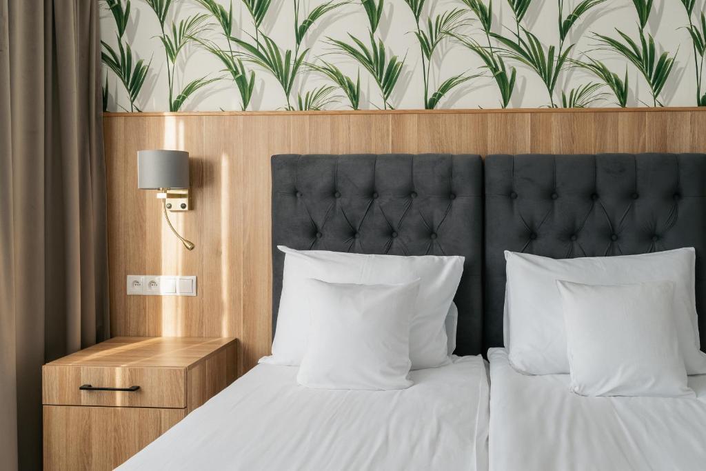a bedroom with a bed with a black headboard and white pillows at Mazurkowa - z widokiem na Karkonosze i Śnieżkę, darmowy parking, obok restauracja Mazurkowa Chata in Jelenia Góra