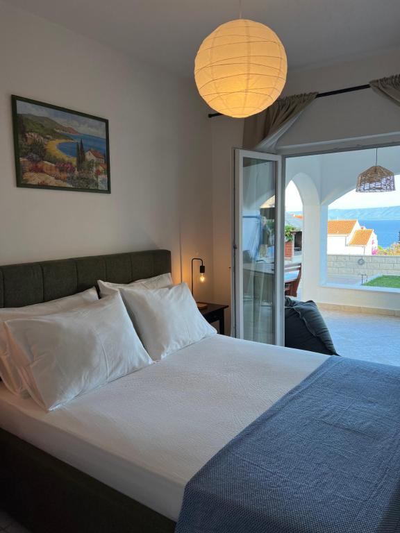 a bedroom with a bed and a view of the ocean at Apartments Mikulić in Bol