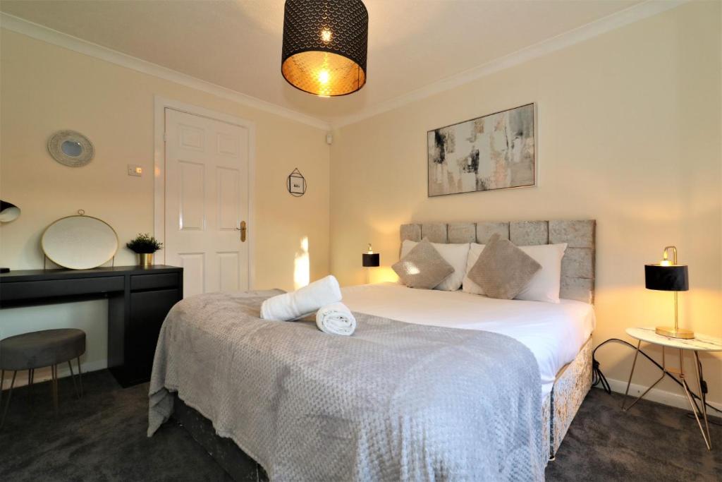 a bedroom with a large bed and a mirror at Signature - Shield House in Scotstoun