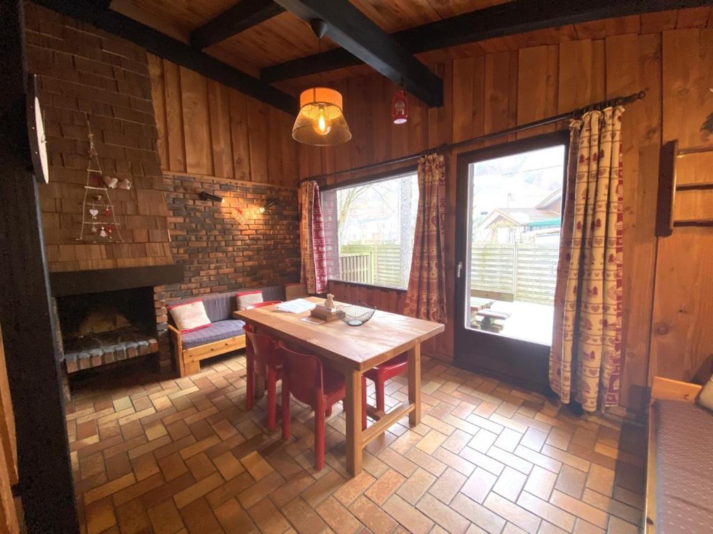 comedor con mesa y chimenea en LA POMME DE PIN 1 Appartement avec terrasse, en La Bresse