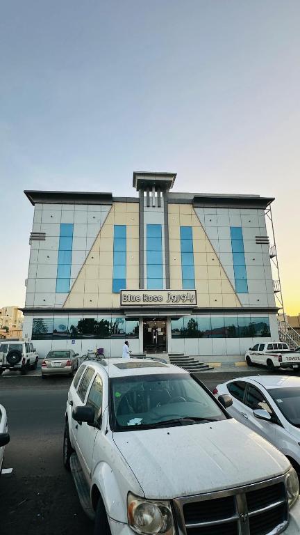 a white car parked in front of a building at أجنحة بلو روز الفندقية in Najran