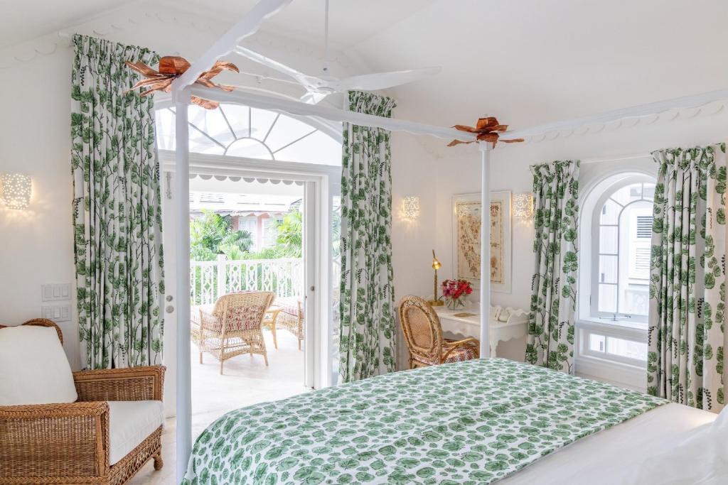 a bedroom with a bed with green and white curtains at Cobblers Cove - Barbados in Saint Peter
