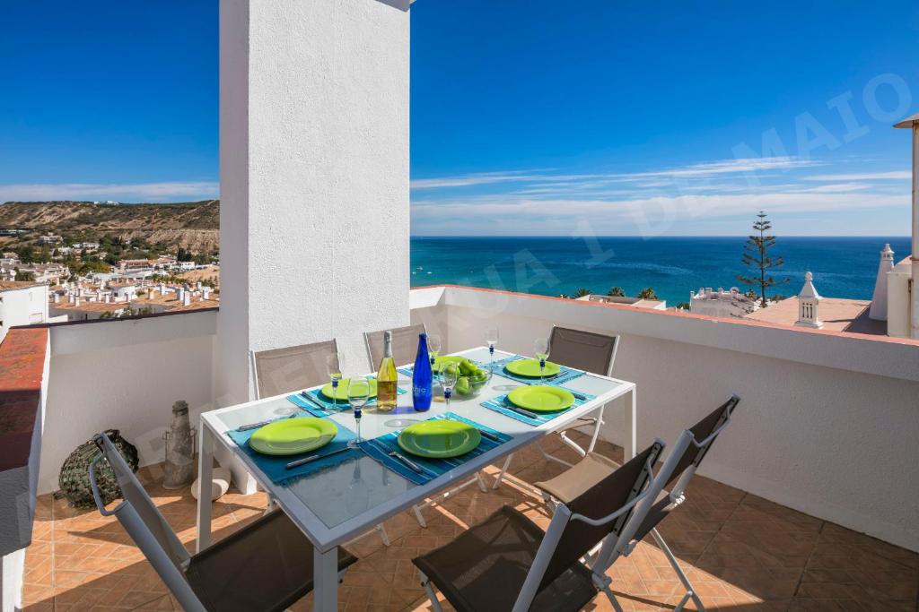 a dining table with chairs and a view of the ocean at Maio Apartment in Luz