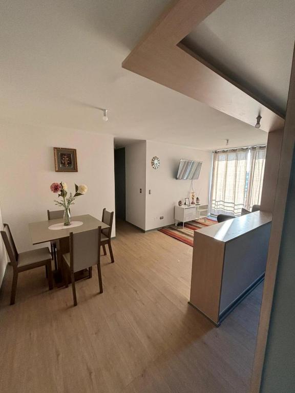 a living room with a table and a dining room at Acogedor departamento arica in Arica