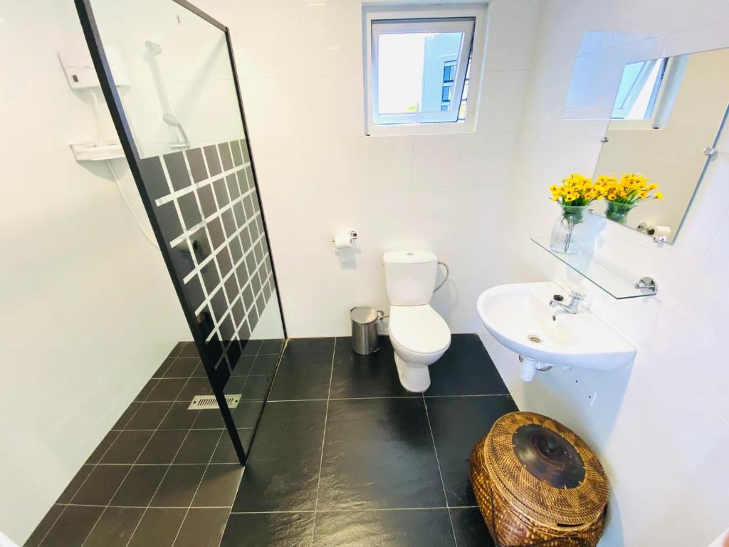 een badkamer met een douche, een toilet en een wastafel bij Alpha Fox the Luxe in Willemstad