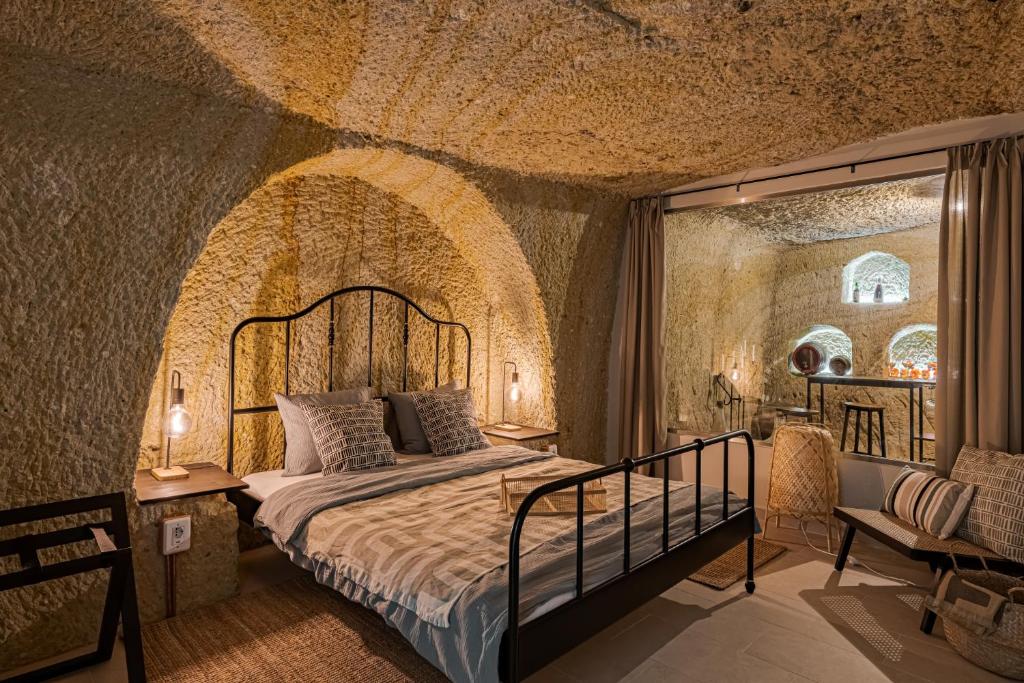 1 dormitorio con 1 cama en una habitación con paredes de piedra en La Cantina, en Demjén