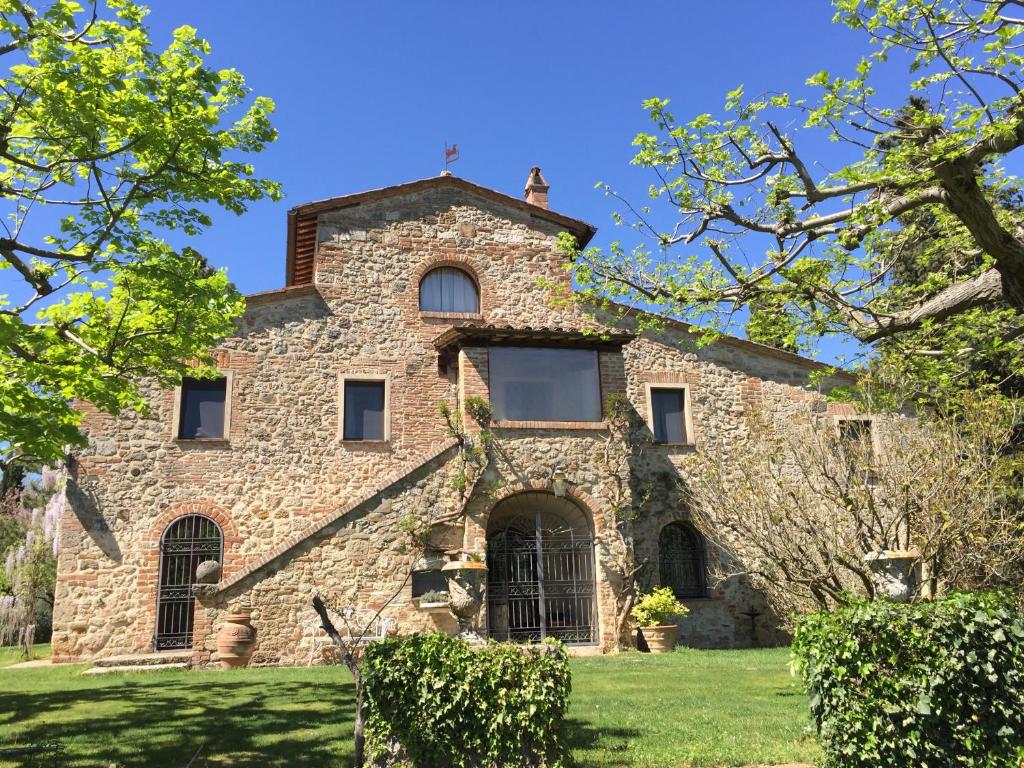 une ancienne maison en pierre sur une pelouse verdoyante dans l'établissement Magnolia House, à Cetona