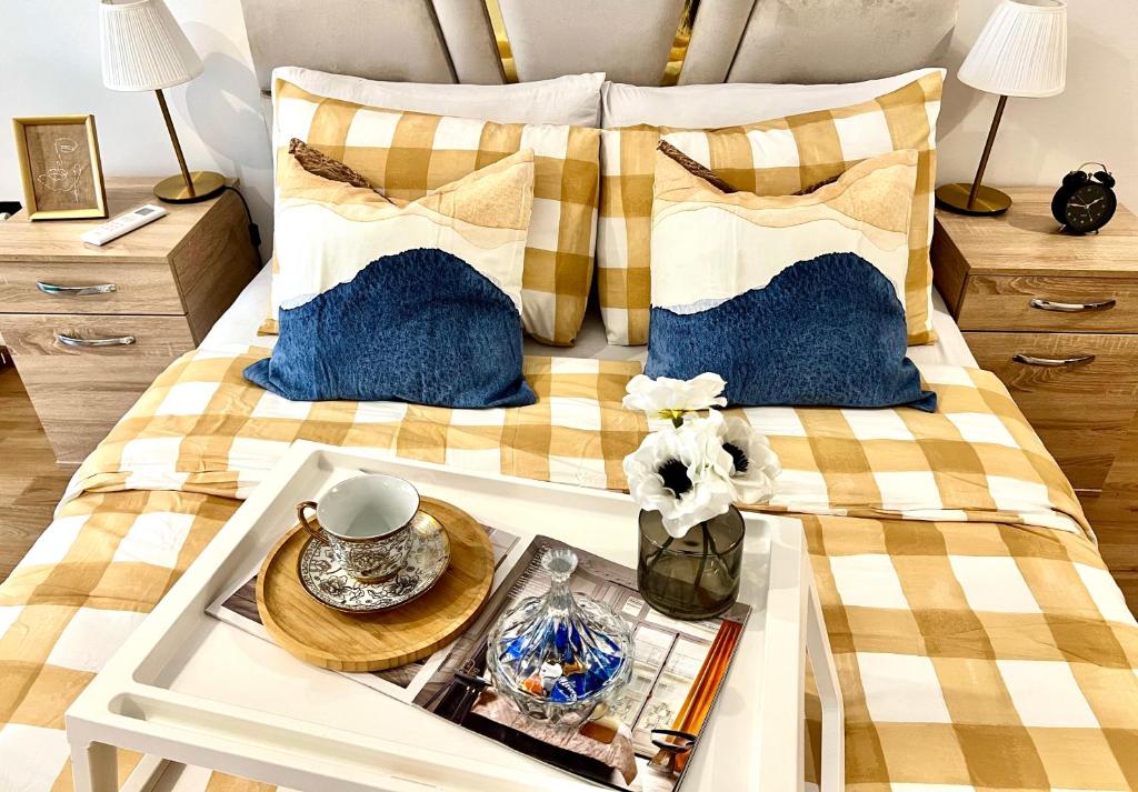 Una cama con almohadas azules y blancas y una bandeja con una mesa. en Rafina A12, en Casablanca