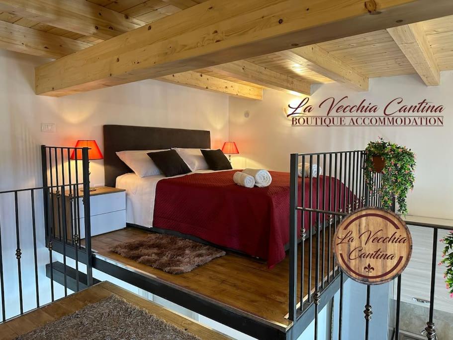 1 dormitorio con cama y techo de madera en La Vecchia Cantina, en Graniti