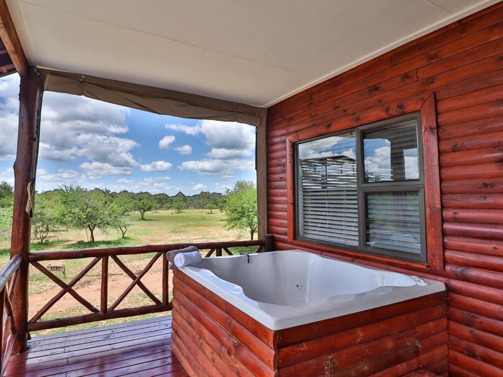 uma grande banheira num quarto com uma janela em Marloth Kruger View em Marloth Park