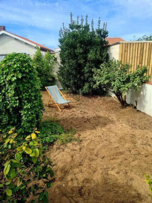 une chaise bleue assise dans une cour à côté d'une clôture dans l'établissement La Tranche Cozy Stay!, à La Tranche-sur-Mer