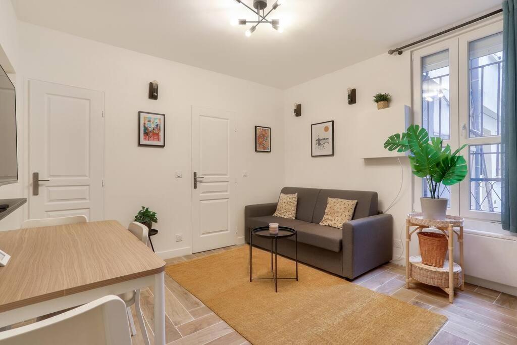 a living room with a couch and a table at Très bel appartement pour 4 aux portes de Paris in Aubervilliers